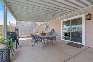 View of patio / terrace with outdoor dining space, a storage unit, and area for grilling