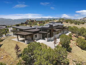 Back of property featuring a patio area, a mountain view, and stone siding