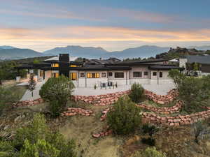 Rear view of property featuring a patio area, stone siding, and a mountain view