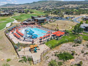 Aerial perspective of suburban area with a mountain backdrop and a golf club