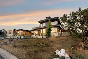 View of front facade featuring stucco siding, stone siding, and covered porch