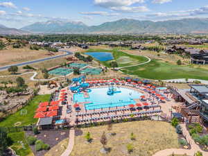 Aerial view of residential area featuring a golf club and a water and mountain view