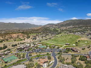 Aerial view of property's location featuring mountains, nearby suburban area, and a golf course