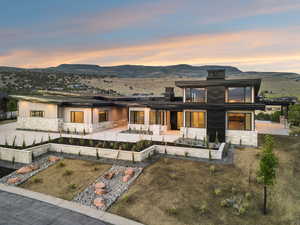 View of front facade featuring stone siding, a patio, a mountain view, and a chimney