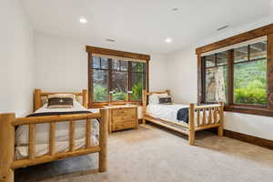 Bedroom with light colored carpet and recessed lighting