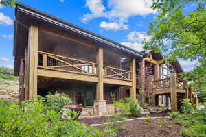 Rear view of property featuring board and batten siding, a wooden deck, and stairway
