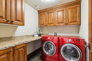 Washroom featuring washing machine and clothes dryer and cabinet space