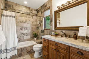 Bathroom featuring tile walls, vanity, and tiled shower / bath