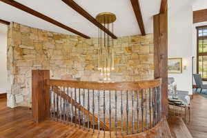 Staircase featuring beamed ceiling and wood finished floors