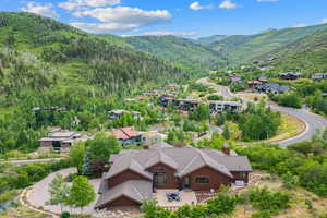 View from above of property with a mountainous background and a heavily wooded area