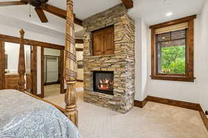 Bedroom with baseboards and a stone fireplace