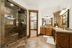 Full bathroom with a stall shower, vanity, and vaulted ceiling