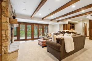 Living room featuring beamed ceiling, recessed lighting, and light carpet