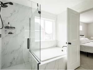 Ensuite bathroom with a marble finish shower and a garden tub