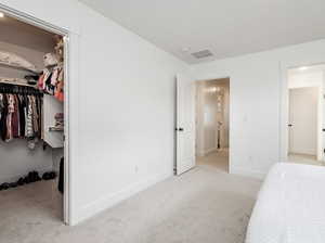 Unfurnished bedroom with carpet floors, a walk in closet, and a closet