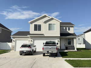 Traditional home featuring driveway, stone siding, an attached garage, and stucco siding