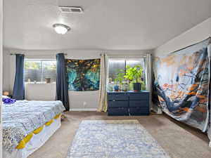 Carpeted bedroom with a textured ceiling