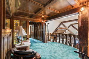 Sitting room with carpet floors, a wood ceiling with exposed beams, crown molding, and coffered ceiling