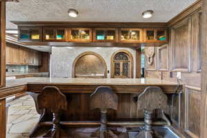 Bar with a textured ceiling and stone finish floors