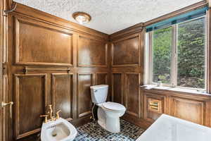 Bathroom featuring a bidet, a textured ceiling, and tile patterned floors