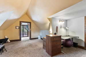 Carpeted office space with radiator heating unit, a textured ceiling, and lofted ceiling
