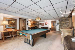 Recreation room featuring a fireplace, carpet floors, pool table, and a paneled ceiling