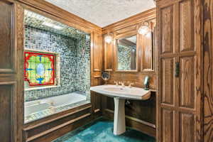 Bathroom featuring a bath and a textured ceiling