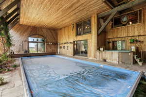 Miscellaneous room with wood ceiling, wooden walls, and lofted ceiling