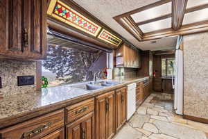 Kitchen featuring stone tile flooring, white appliances, tasteful backsplash, and ornamental molding