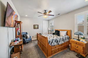 Bedroom with dark colored carpet, recessed lighting, and a ceiling fan