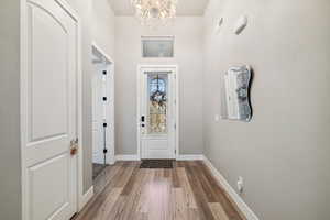 Foyer entrance with a chandelier and wood finished floors