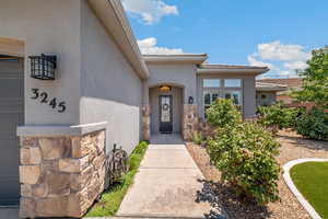 View of exterior entry featuring stucco siding and a tiled roof