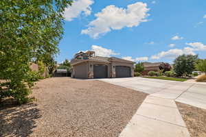 View of front of home featuring driveway, a garage, stone siding, and stucco siding