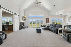 Carpeted living room with a desk, ceiling fan, high vaulted ceiling, recessed lighting, and a barn door