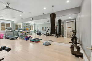 Exercise room with a ceiling fan, wood finished floors, and recessed lighting