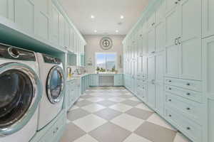 Laundry area with separate washer and dryer, light floors, recessed lighting, and cabinet space