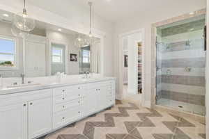 Full bathroom featuring double vanity, a shower stall, a walk in closet, recessed lighting, and tile patterned floors