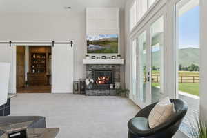 Living area featuring a barn door, carpet floors, a fireplace, and a mountain view