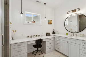 Bathroom featuring vanity and a shower