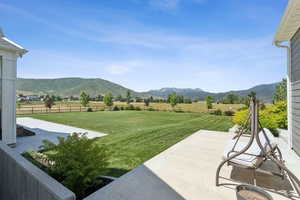 View of yard with a patio, a mountain view, and a view of rural / pastoral area