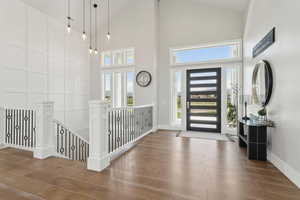 Foyer entrance with a towering ceiling and wood finished floors