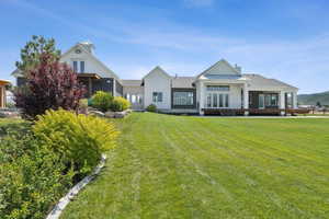 View of front facade featuring french doors, board and batten siding, a front yard, and a chimney