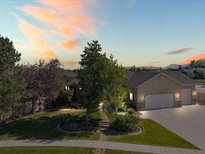 View of front of home featuring a garage, stucco siding, a front yard, and driveway