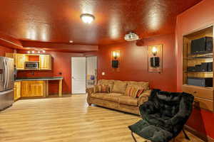 Home Theater with light wood-style floors and a textured ceiling