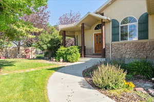 Property entrance featuring stone siding and stucco siding