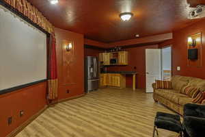 Living area featuring light wood-type flooring and a textured ceiling
