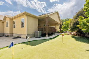View of side of home featuring an area to practice putting, a patio area, and stucco siding