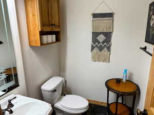 Half bath with toilet and a sink - situated just off of the kitchen.