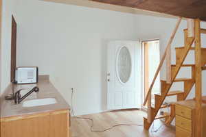 Entrance foyer featuring stairs, light wood-type flooring, and plenty of natural light