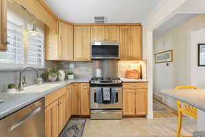 Kitchen featuring stainless steel appliances, backsplash, and light countertops